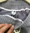 Close-up of brand hangtag attached to corduroy jogger pants, wholesale stocklot