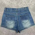 High-waisted distressed denim shorts, back view