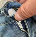 Close-up of button closure and waistband on denim shorts