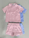 Close-up of premium contrast piping line work and glossy smooth satin fabric texture on children sleepwear