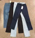 Overhead group display of assorted color choices including dark indigo, light ice blue, classic black, and medium wash jeans