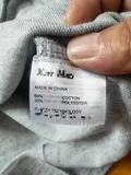 Care label close-up showing 65% cotton 35% polyester and made in China on men's polo shirt for wholesale