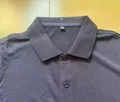 Close-up of navy men's polo shirt collar, two-button placket, and M size label for wholesale listing
