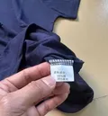 Fabric care label showing 65% cotton 35% spandex composition on men's polo shirt wholesale stock