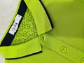 Close-up of lime green polo shirt collar with honeycomb geometric inner lining and two-button placket detail
