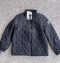 Black men's diamond quilted lightweight puffer jacket flat lay showing stand-up collar full zipper and side pockets for wholesale buyers