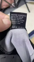 Garment laundering instructions and heavy cotton-blend stretch fabric care label sewn inside men's tactical shorts
