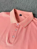 Men's coral polo shirt flat lay showing three-button placket and ribbed cuffs for wholesale bulk buyers