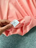 Close-up of men's polo shirt collar with contrast piping detail and 2XL size label for wholesale inventory