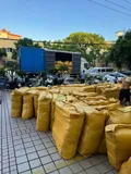 Shipping container loaded with bulk factory overstock men's polo shirts in woven bags ready for export distribution