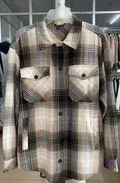 Women's cotton plaid shacket hanging on hanger showing full button placket and flap chest pockets in black white check pattern