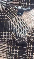 Close-up of women's plaid shacket collar and self-fabric belt detail with S/P size label for wholesale buyers
