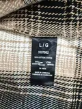 Care label showing 100% cotton and made in Cambodia on women's plaid shacket with L/G size and CA 16035 for wholesale lot