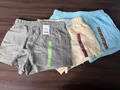 Close-up of women's cotton shorts waistband with contrast cream ribbed elastic panel and size 8 label for wholesale lot