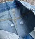 Interior button and stitching detail of women's curved jeans wholesale lot for online sellers
