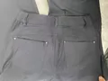 Rear perspective of women's fluid drape dress pants showing neat tailored back darts and clean trouser seat lines