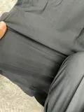 Close-up of the clean hidden-elastic waistband structure featuring a durable secure center button closure on professional slacks