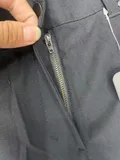 Close-up of the clean hidden-elastic waistband structure featuring a durable secure center button closure on professional slacks