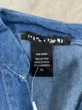 Fabric content and laundering instructions care label inside women's long sleeve lightweight denim top