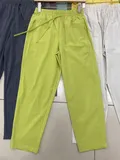 Three-color display of women's lightweight casual pants including lime green navy and cream for bulk sourcing