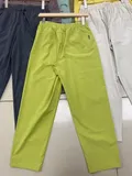Rear view of women's lime green casual pants showing waistband and pocket detail for wholesale stock
