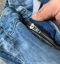 Close-up of zipper and waistband on women's rigid denim wide-leg jeans for bulk apparel sourcing